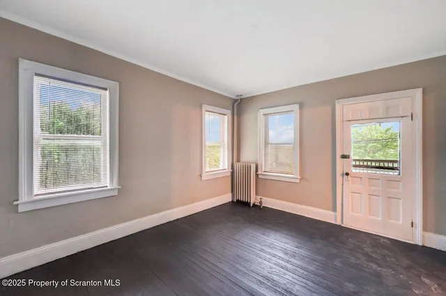 a view of entryway and gallery with wooden floor