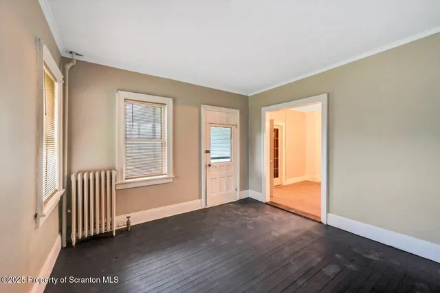 a view of a hallway with entryway wooden floor and front door