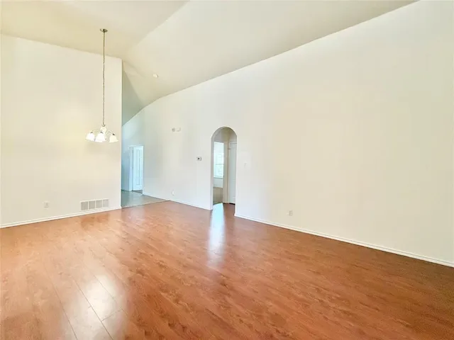 a view of empty room with wooden floor and window