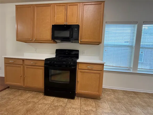 a kitchen with stainless steel appliances granite countertop white cabinets granite counter tops and a window