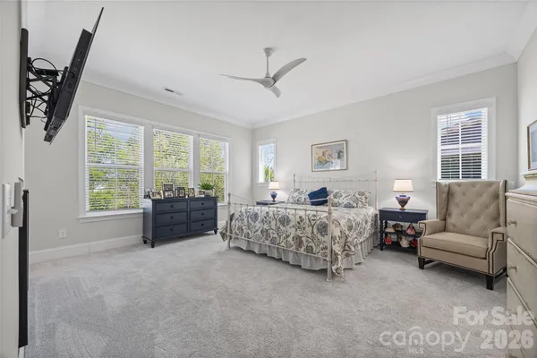 a spacious bedroom with a bed and a flat screen tv