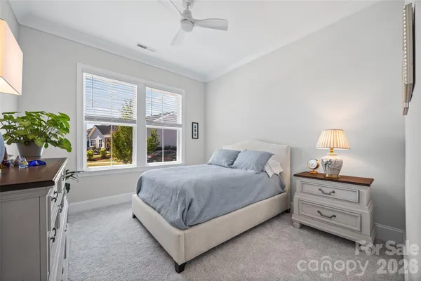 a spacious bedroom with a bed and a potted plant