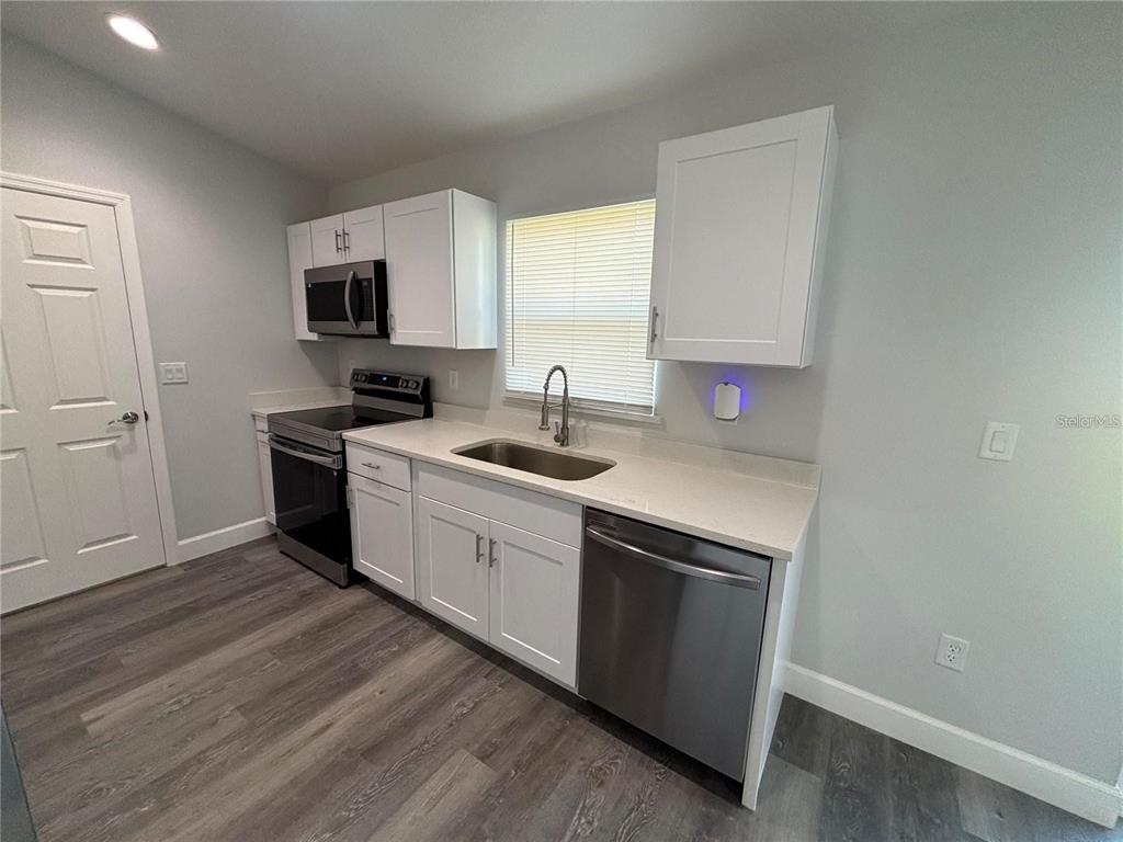 13187 Southwest 103rd Place Dunnellon, FL 34432 - Photo 10 of 49 a kitchen with a sink cabinets and wooden floor