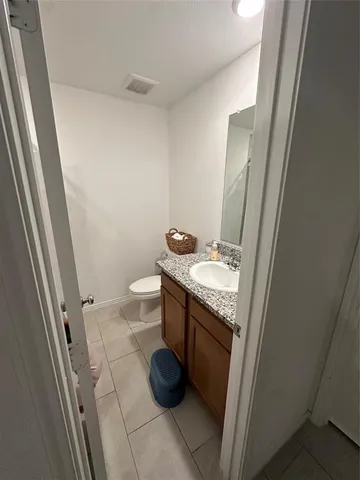 a bathroom with a granite countertop sink toilet and a mirror