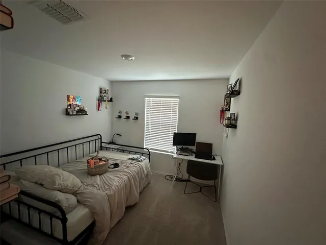 a bedroom with a bed and a desk