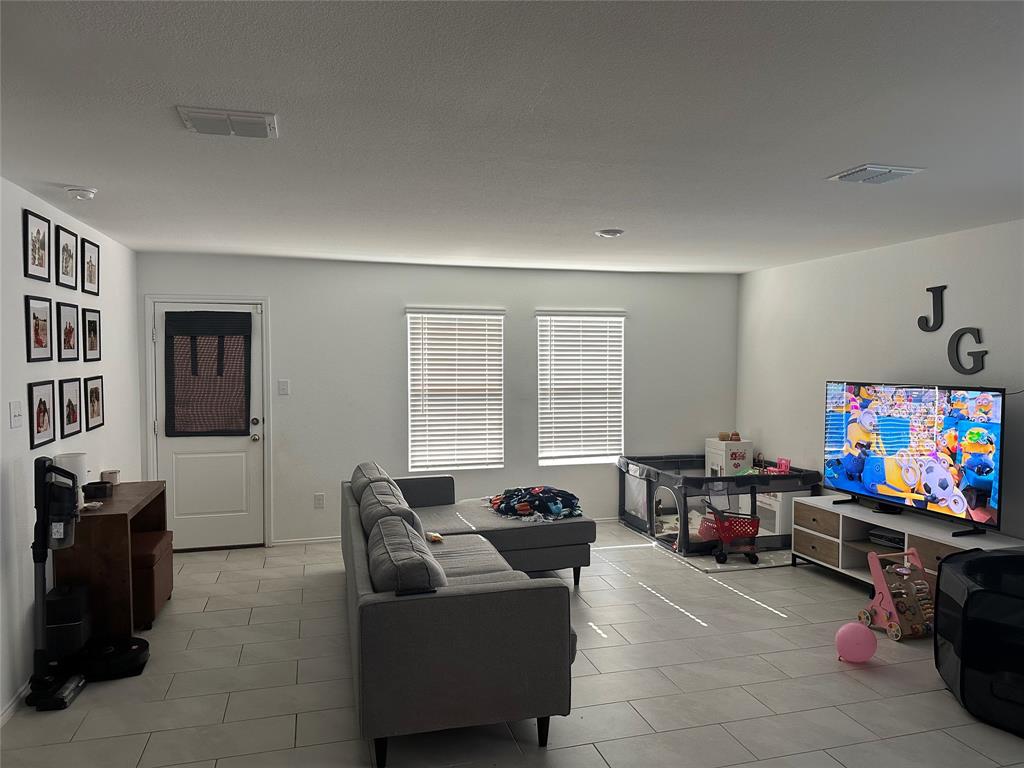 2928 Dora Drive Fort Worth, TX 76119 - Photo 3 of 15 a living room with furniture a flat screen tv and a window