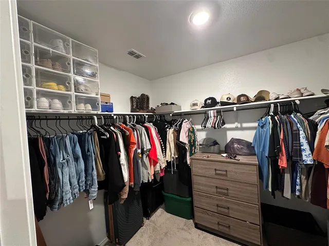 a view of walk in closet with clothes and shoes