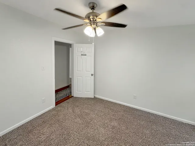 an empty room with closet and a chandelier fan