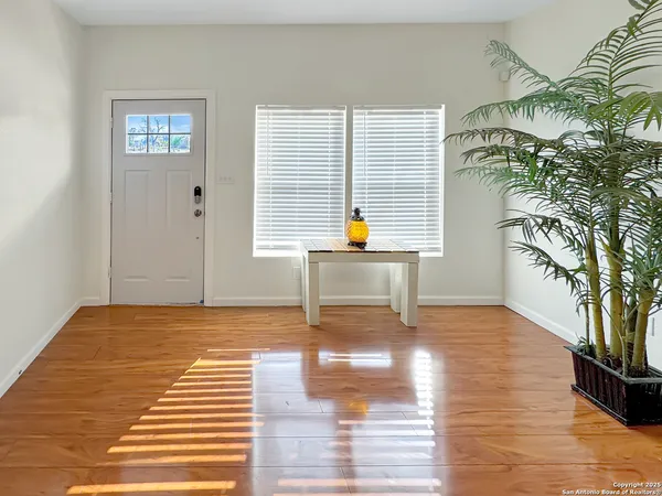 a view of empty room with wooden floor and fan