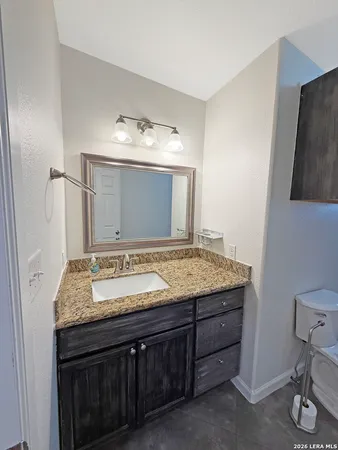 a bathroom with a granite countertop sink and a mirror
