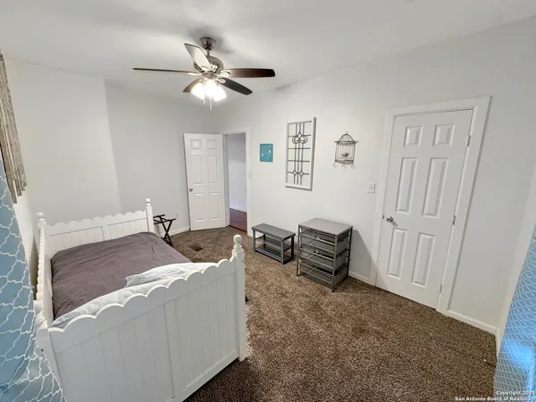 a living room with furniture and a ceiling fan