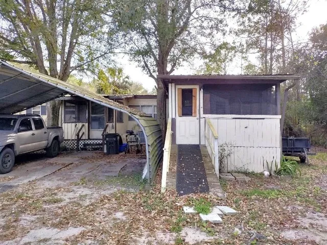 a view of a house with a yard and car parked