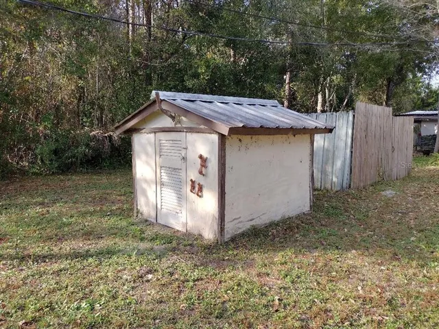 a view of a house with a yard and large tree