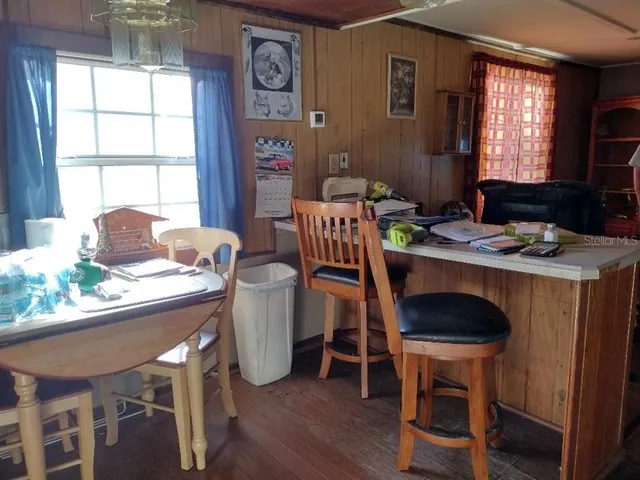 a dining room with furniture a window and wooden floor
