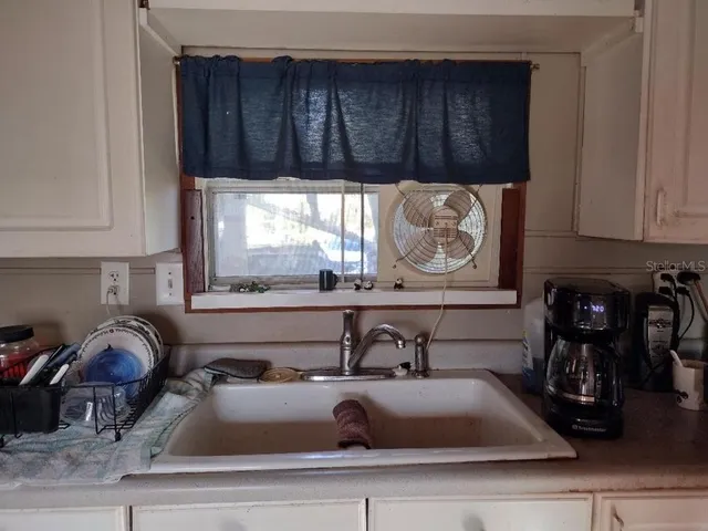 a kitchen with a sink and a stove with wooden floor