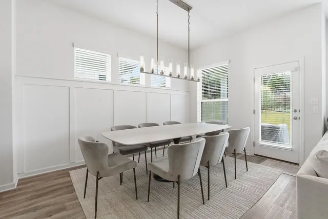 a view of a dining room with furniture wooden floor and chandelier