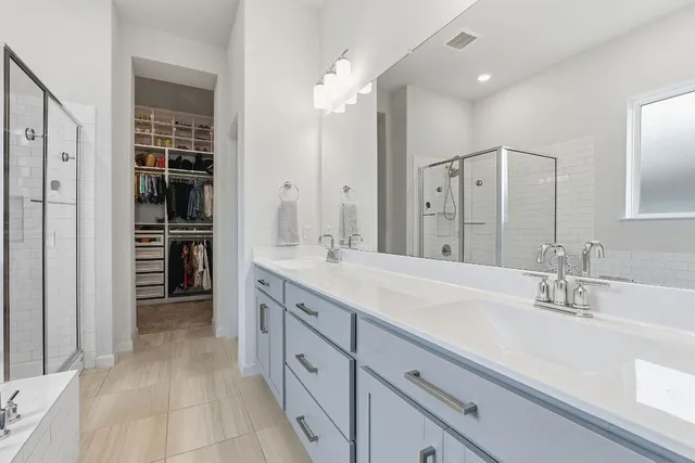 a spacious bathroom with a double vanity sink shower and a mirror