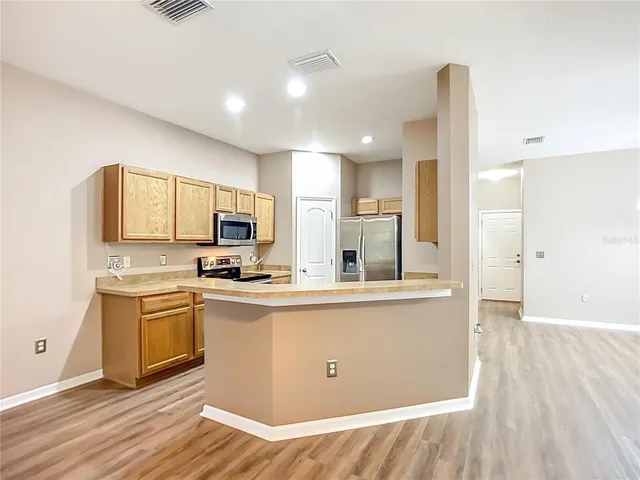 a kitchen with stainless steel appliances granite countertop a stove a sink and a refrigerator