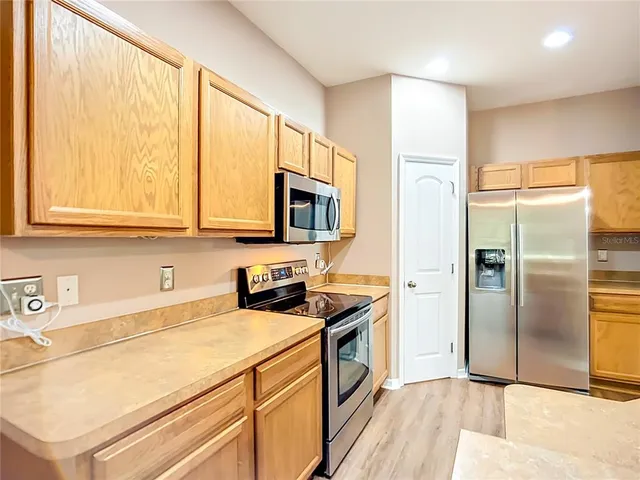 a kitchen with stainless steel appliances a refrigerator sink and microwave