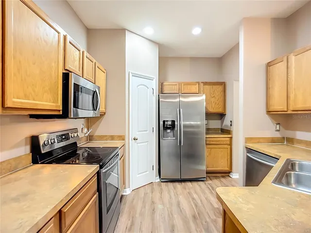 a kitchen with stainless steel appliances granite countertop a refrigerator stove top oven a sink and dishwasher