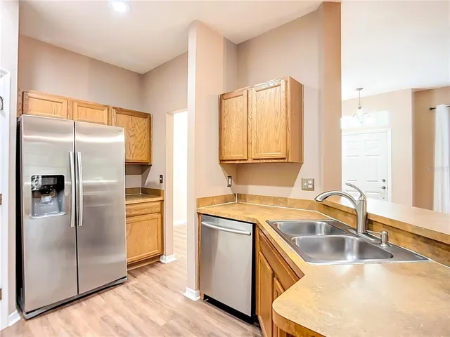 a kitchen with a refrigerator sink and cabinets