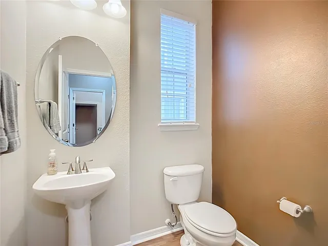 a bathroom with a toilet a sink and a mirror