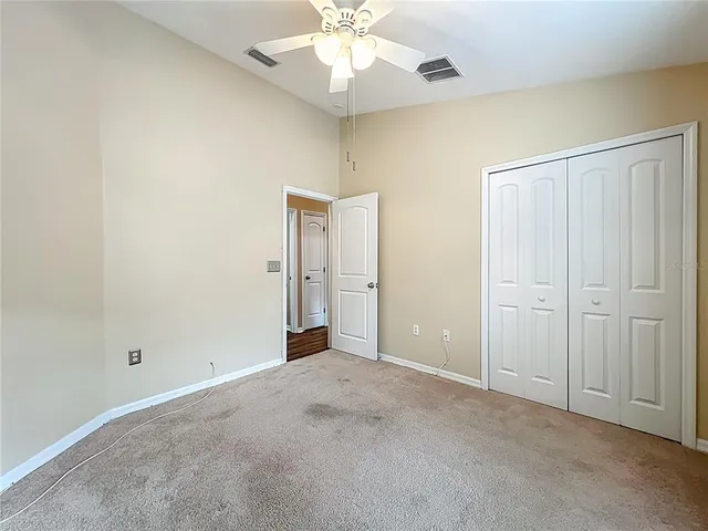 an empty room with fan and entrance