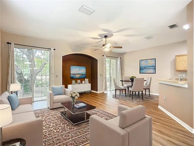 a living room with furniture chandelier and a large window
