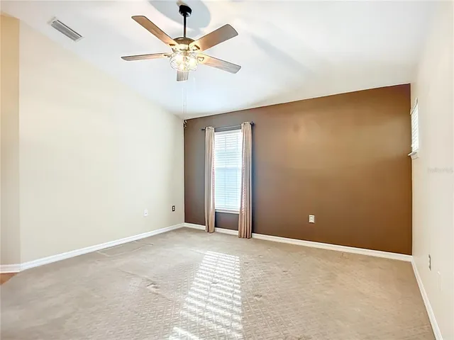 an empty room and chandelier fan