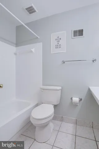 a white toilet sitting next to a bath tub