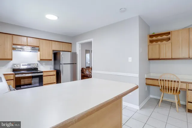 a kitchen with stainless steel appliances a refrigerator and a stove top oven