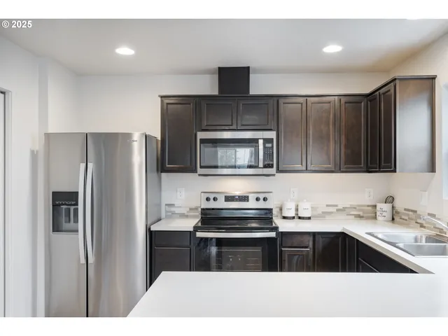 a kitchen with kitchen island a sink stainless steel appliances and cabinets
