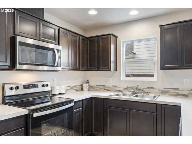 a kitchen with a sink stove top oven and cabinets