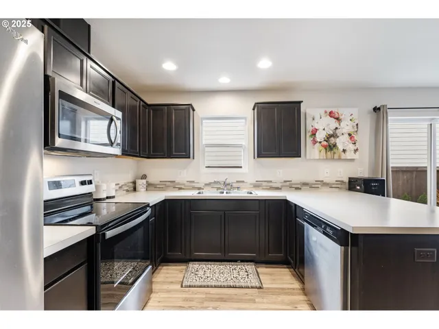a kitchen with stainless steel appliances granite countertop a sink stove and cabinets