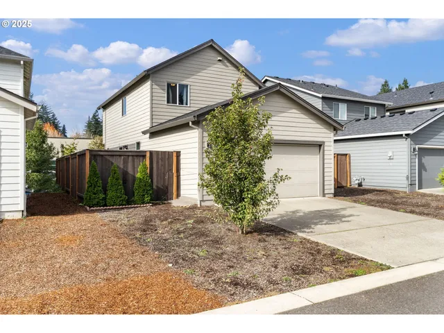a view of a house with a yard and potted plants