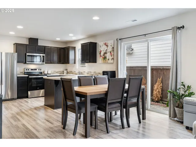 a open kitchen with stainless steel appliances kitchen island granite countertop a stove a sink a dining table and chairs