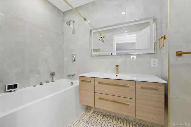 a bathroom with a tub a sink and mirror
