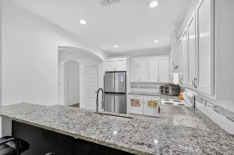 a kitchen with stainless steel appliances granite countertop a sink stove and refrigerator