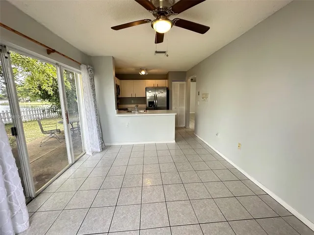 a view of a livingroom with a chandelier fan and windows