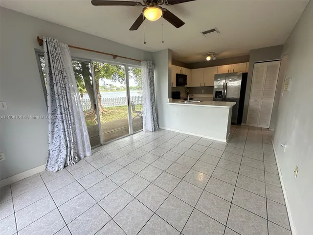 a open kitchen with stainless steel appliances granite countertop a refrigerator and a stove top oven