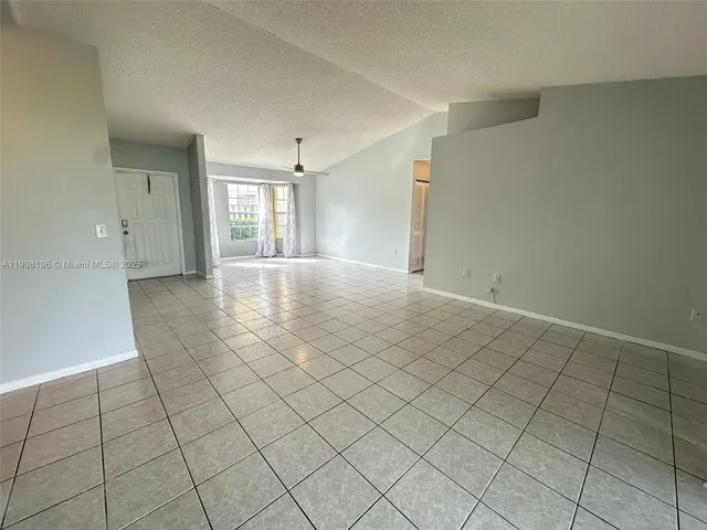 an empty room with windows and cabinet