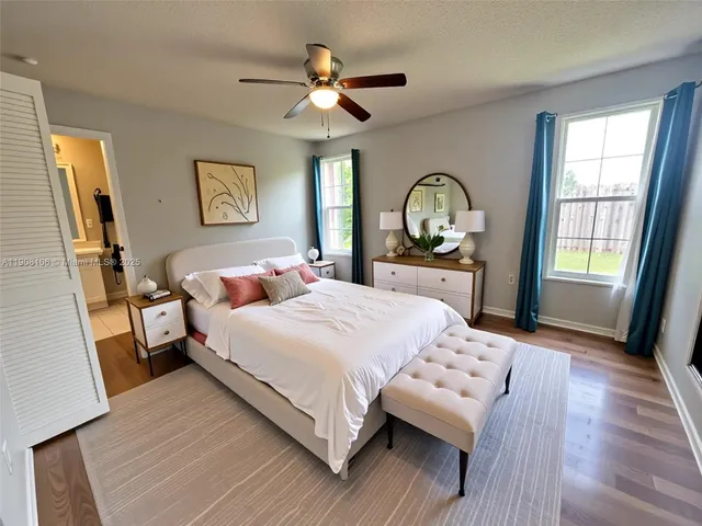 a bedroom with a bed and a large window with wooden floor