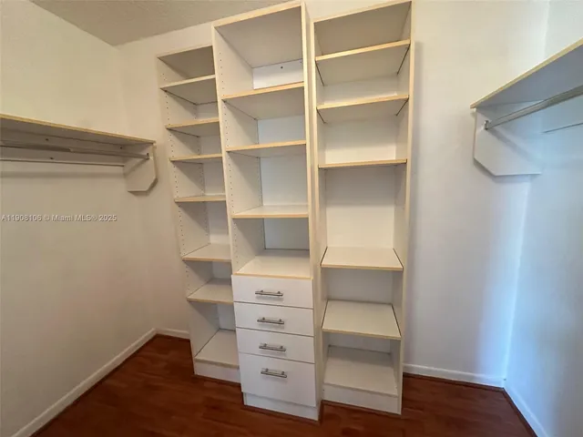 a view of walk in closet with empty racks