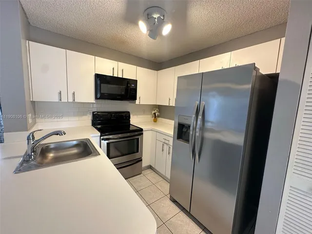 a kitchen with a refrigerator a microwave a sink and a stove