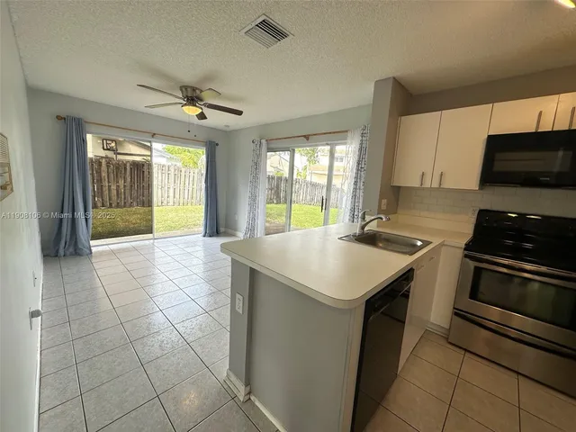 a kitchen with a sink a counter top space cabinets and stainless steel appliances