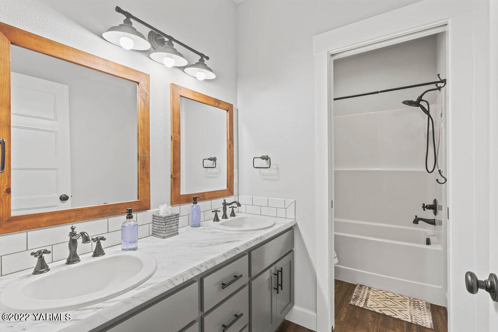 1058 East Road Bickleton, WA 99322 - Photo 15 of 39 a bathroom with a granite countertop sink a mirror and a shower