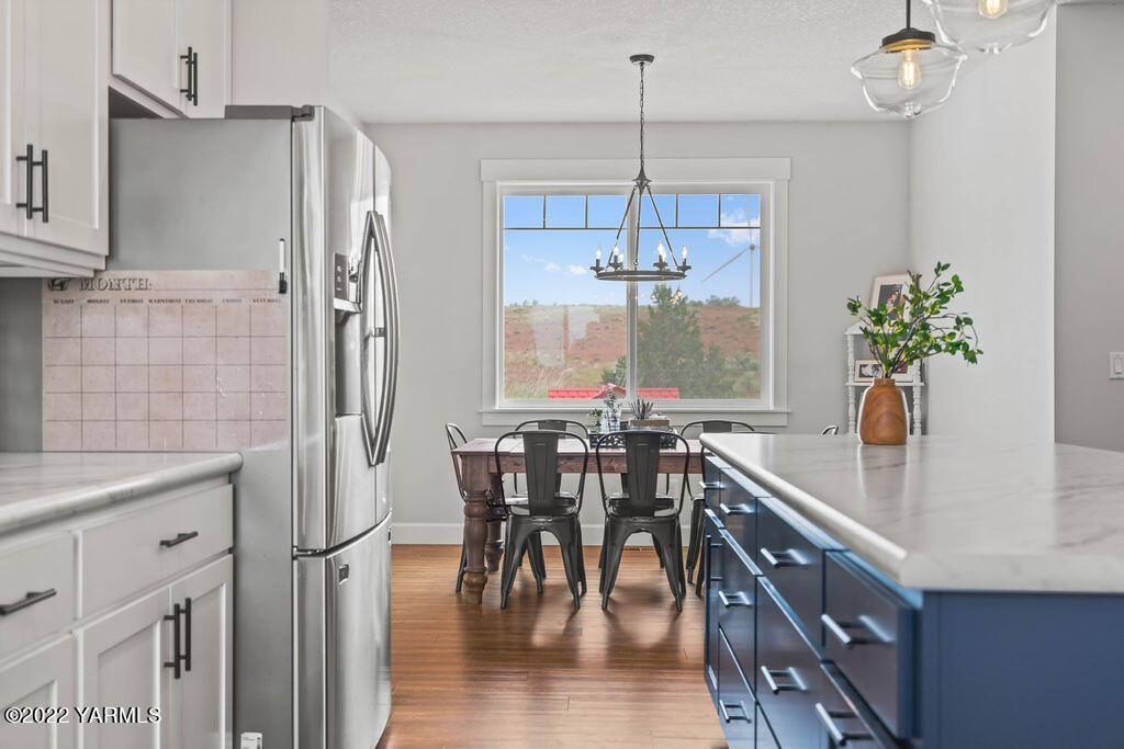 1058 East Road Bickleton, WA 99322 - Photo 25 of 39 an open kitchen with granite countertop a table and chairs in it