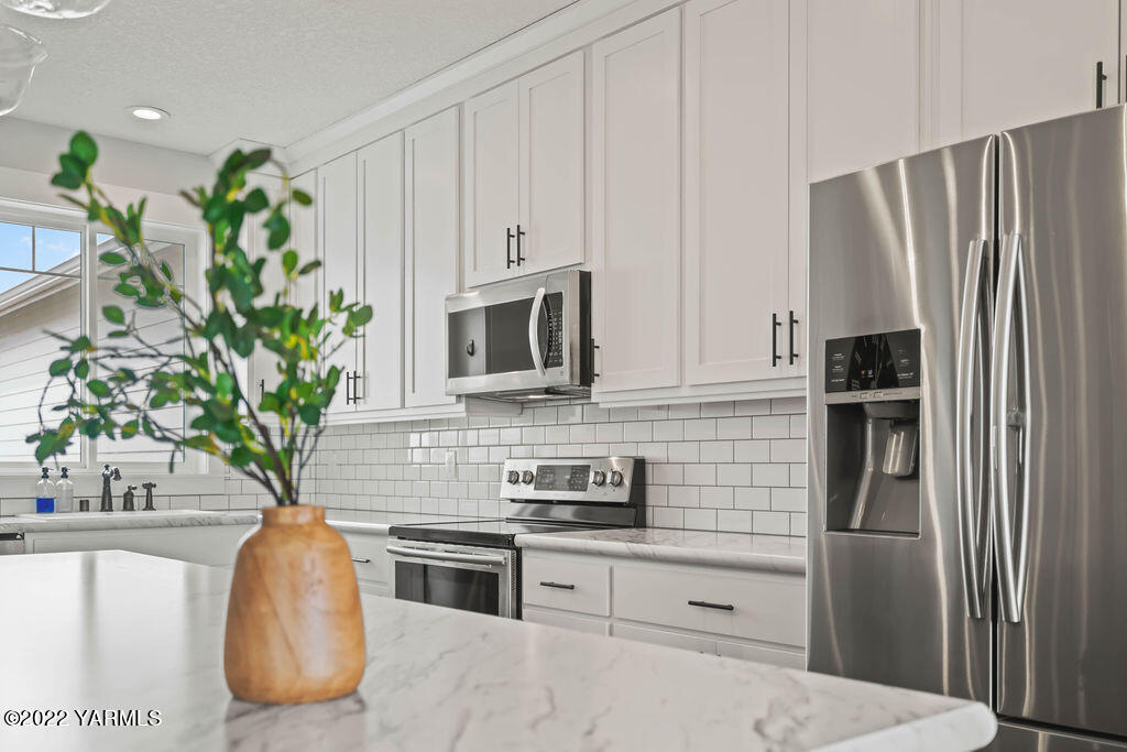 1058 East Road Bickleton, WA 99322 - Photo 27 of 39 a kitchen with stainless steel appliances a refrigerator a sink a stove a microwave and cabinets