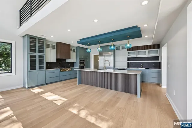 a kitchen with stainless steel appliances kitchen island granite countertop a refrigerator and a sink