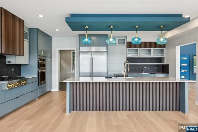 a kitchen with stainless steel appliances granite countertop a refrigerator and a stove top oven